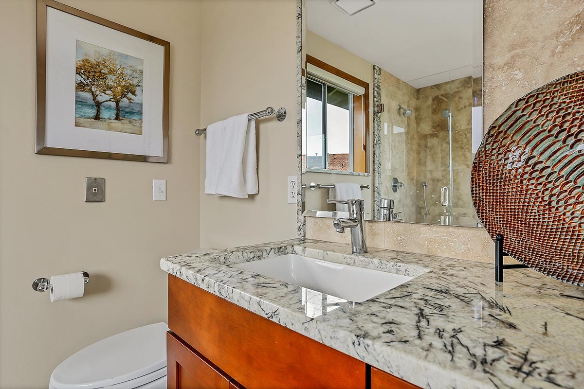 Granite countertops in bathroom with large mirror